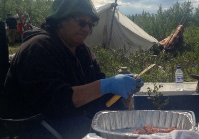 Annie Wabano cutting up fish during a youth camping trip back in August.